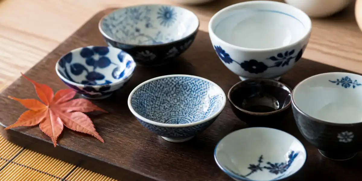 Plateau de petits plats japonais de saison dans des bols en laque et en porcelaine bleu et blanc