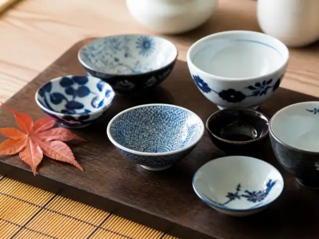 Plateau de petits plats japonais de saison dans des bols en laque et en porcelaine bleu et blanc